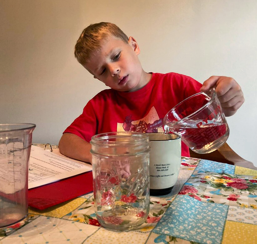 Boy measures water with measuring cup